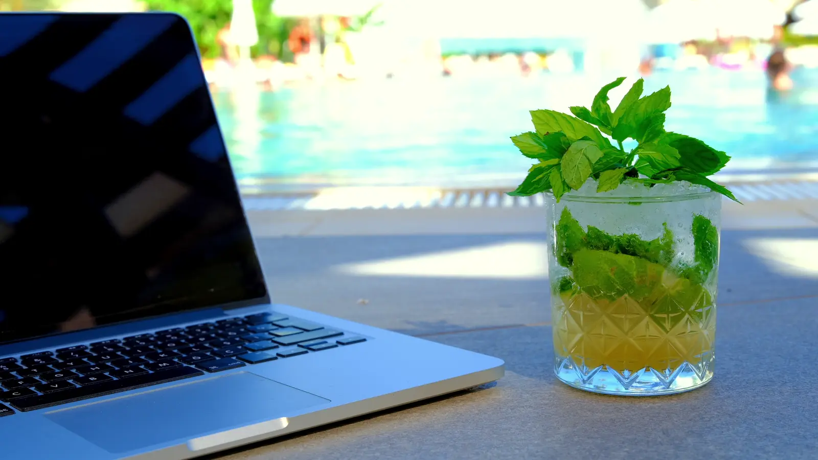 Notebook junto a una piscina en un día de sol